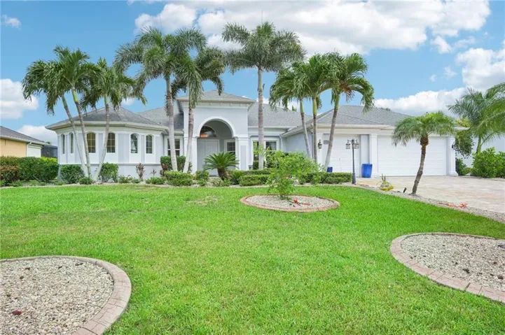 View of front of house featuring a front yard, driveway, stucco siding, and an attached garage
