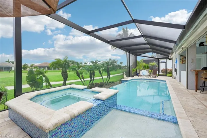 View of pool with a patio, a yard, a pool with connected hot tub, and a lanai