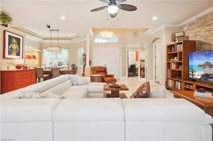 Living room with crown molding, tile patterned flooring, recessed lighting, and a ceiling fan