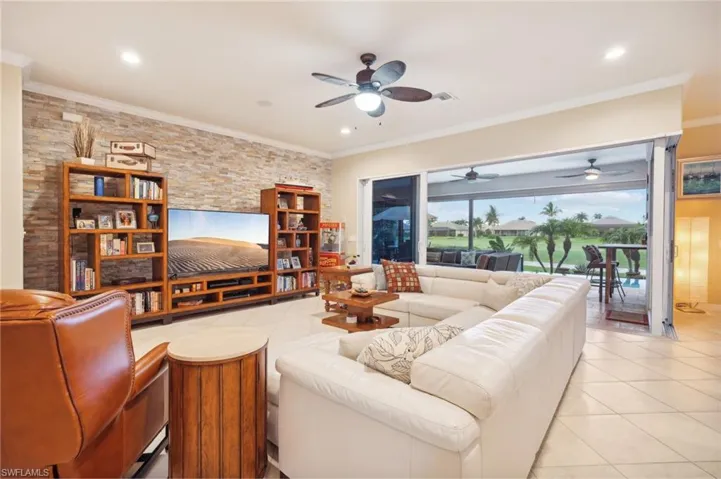 Living area featuring light tile patterned floors, recessed lighting, ornamental molding, and a ceiling fan