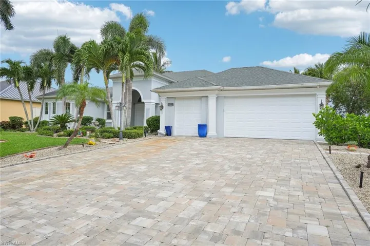 View of front of property featuring decorative driveway, stucco siding, and an attached garage
