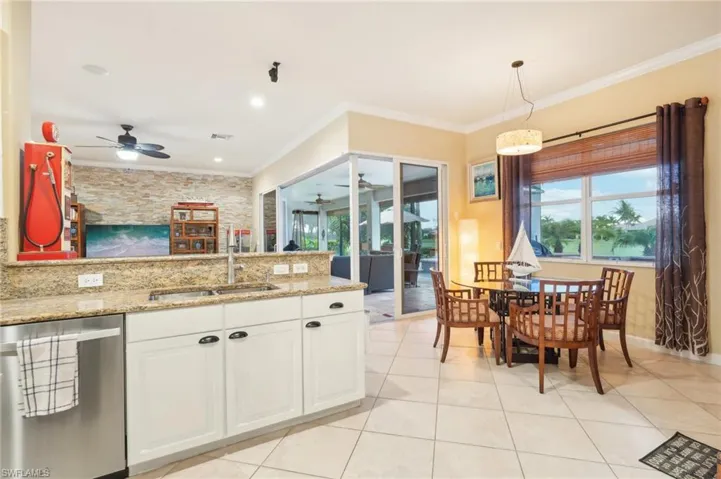 Kitchen with ornamental molding, stainless steel dishwasher, a sink, ceiling fan, and white cabinets