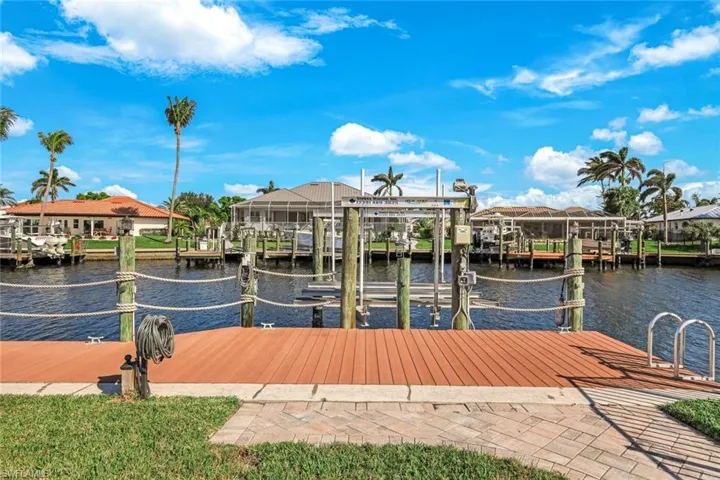 View of dock featuring a water view, a residential view, and boat lift