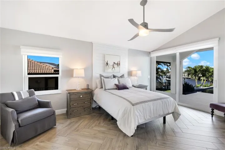 Bedroom featuring access to outside, baseboards, a ceiling fan, and lofted ceiling