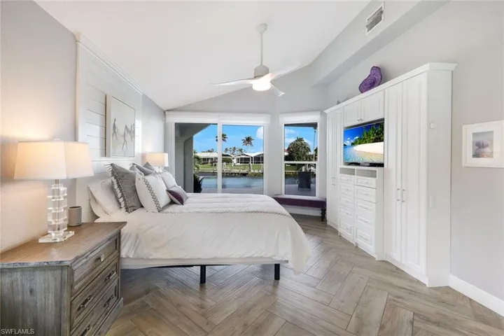 Bedroom featuring visible vents, baseboards, a ceiling fan, access to outside, and lofted ceiling