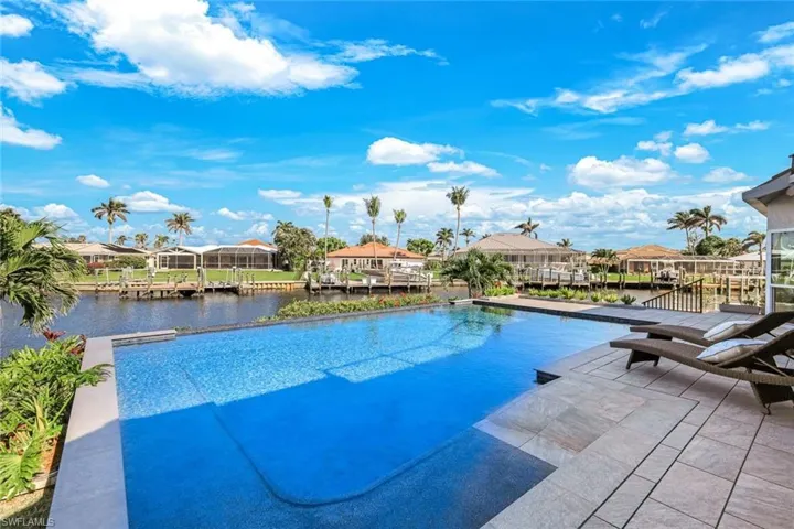 View of pool with a dock, a residential view, and a water view