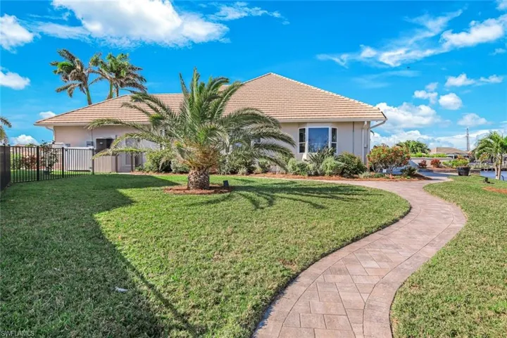 Back of property featuring fence, a lawn, and stucco siding