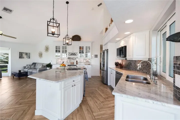 Kitchen with tasteful backsplash, visible vents, a center island, a sink, and appliances with stainless steel finishes