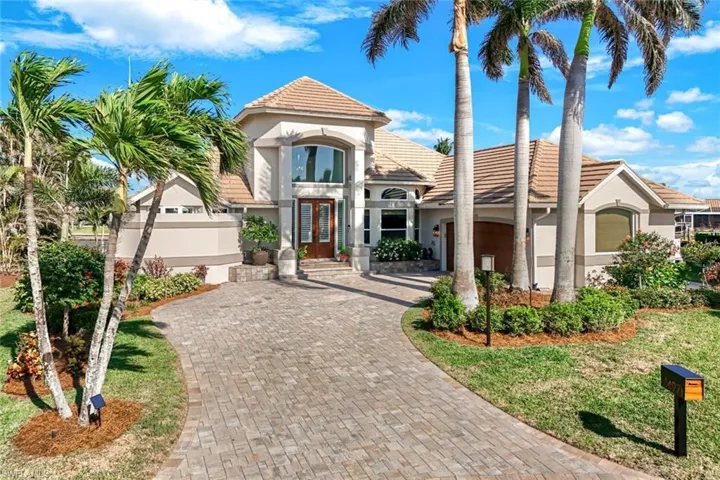 Mediterranean / spanish house featuring a tiled roof, a garage, stucco siding, french doors, and decorative driveway