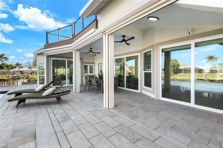 View of patio / terrace featuring ceiling fan, a water view, and a balcony