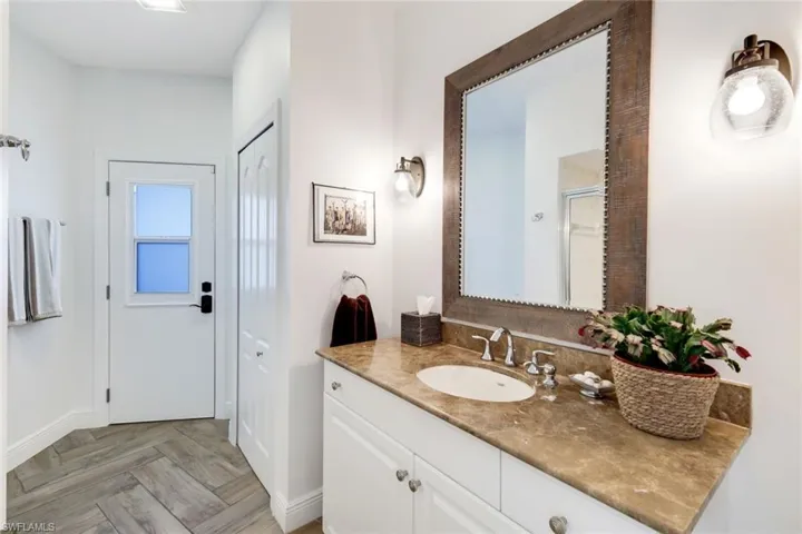 Bathroom featuring vanity, baseboards, and a stall shower