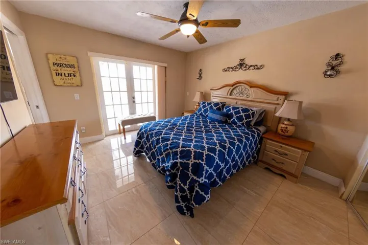 Bedroom featuring french doors, a ceiling fan, and a textured ceiling