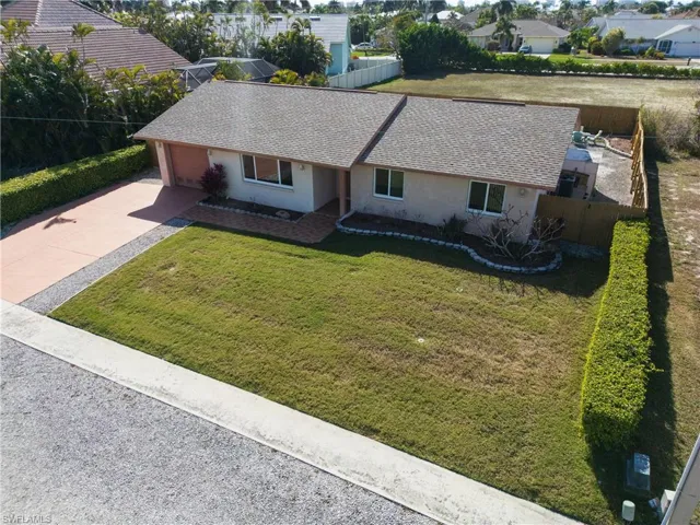 Single story home featuring stucco siding, driveway, roof with shingles, and a garage
