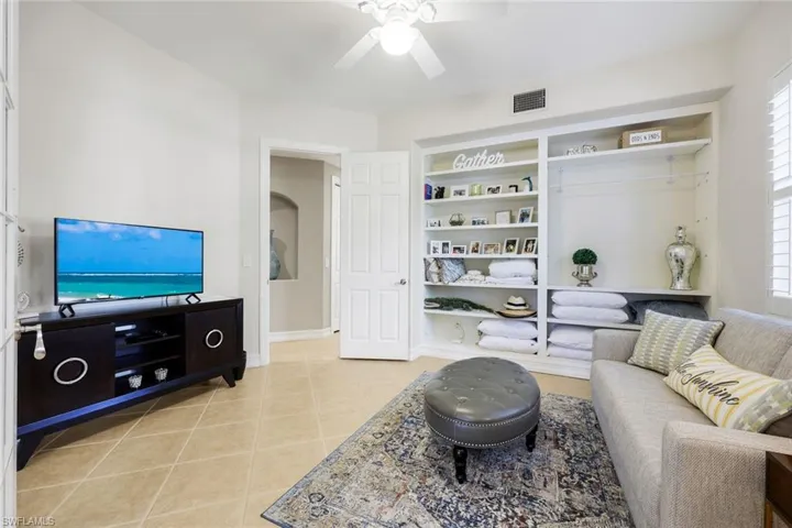 Living room featuring a ceiling fan and light tile patterned floors