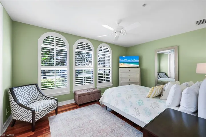 Bedroom with dark wood-style flooring and ceiling fan