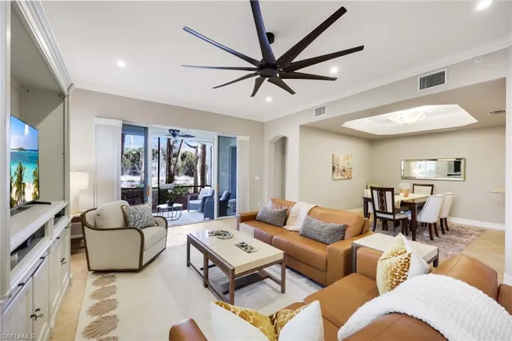 Living area featuring ornamental molding, light tile patterned floors, recessed lighting, arched walkways, and ceiling fan