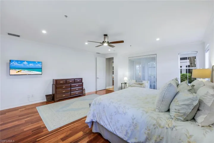 Bedroom with crown molding, wood finished floors, a ceiling fan, and recessed lighting