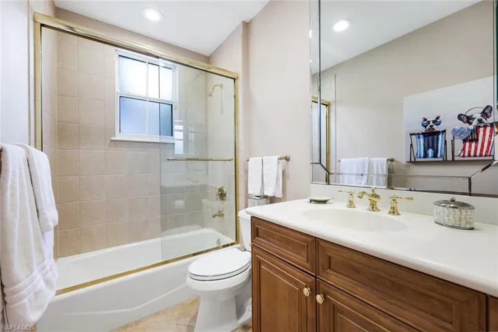 Bathroom with enclosed tub / shower combo, vanity, recessed lighting, and light tile patterned floors