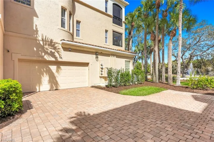 View of front of property with an attached garage, stucco siding, and decorative driveway