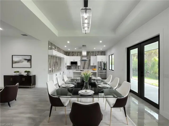 Dining area featuring a wealth of natural light, an inviting chandelier, and french doors