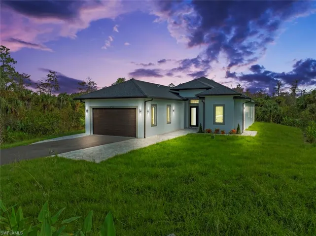 Prairie-style house featuring a garage and a lawn