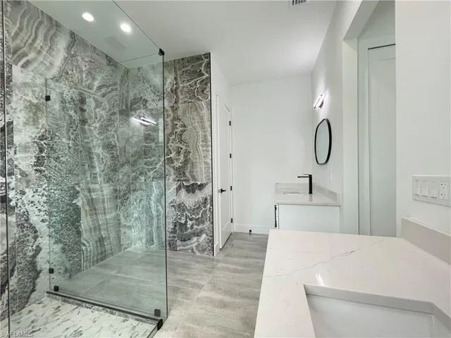 Bathroom featuring vanity and an enclosed shower