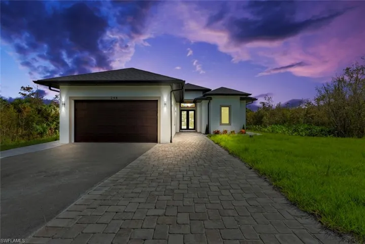 View of front of house with a yard and a garage