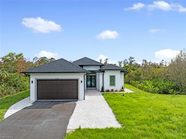 View of front of home featuring a garage and a front lawn
