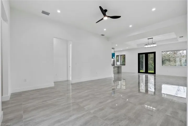 Unfurnished living room featuring french doors and ceiling fan