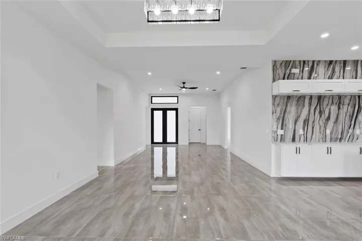 Entrance foyer with ceiling fan and a tray ceiling