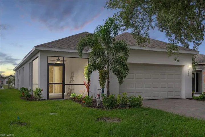 View of front of property with a garage and a lawn