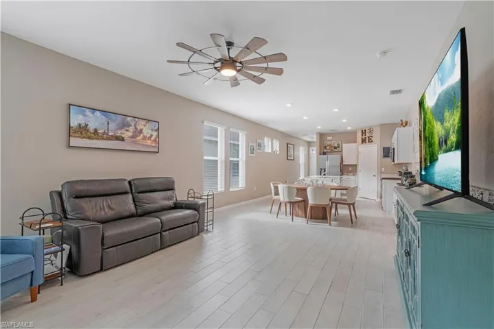 Living room featuring ceiling fan, sink, and light hardwood / wood-style flooring
