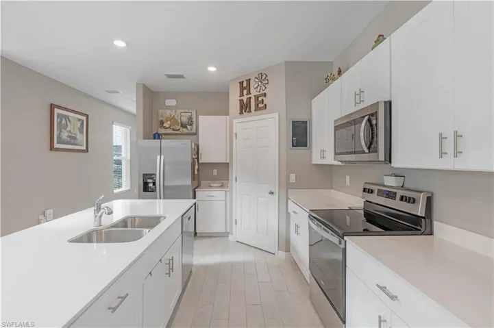 Kitchen featuring white cabinets, appliances with stainless steel finishes, and sink
