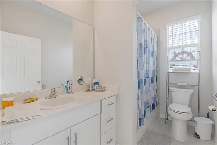 Bathroom with tile flooring, toilet, and large vanity