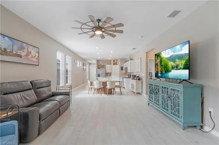 Living room with ceiling fan and light hardwood / wood-style flooring