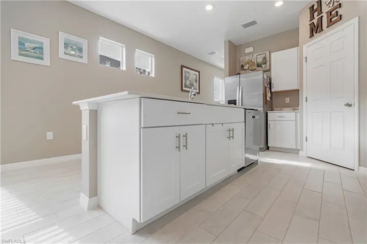 Kitchen featuring white cabinetry and light tile floors