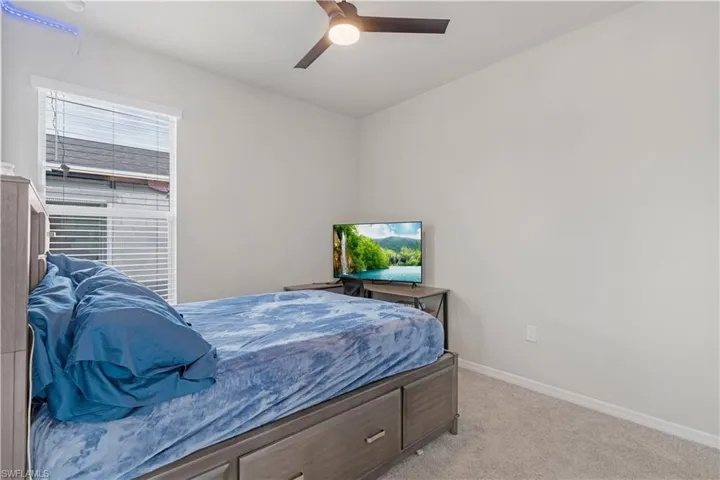 Carpeted bedroom with ceiling fan