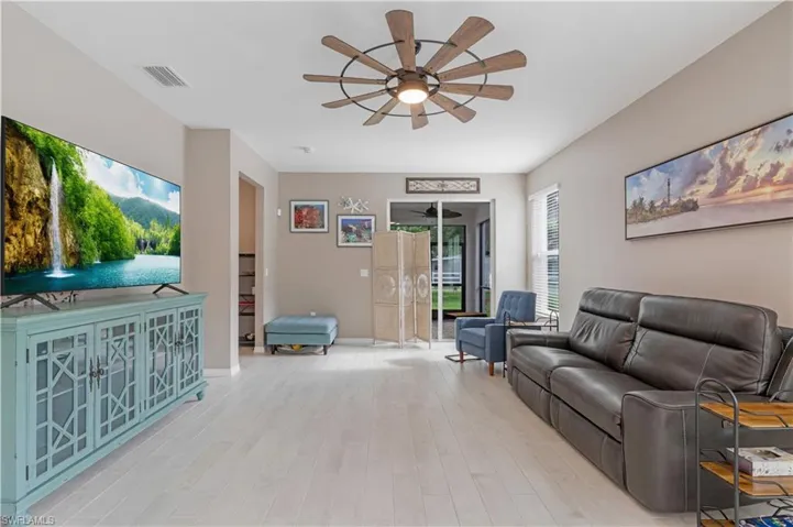 Living room with ceiling fan and light hardwood / wood-style flooring