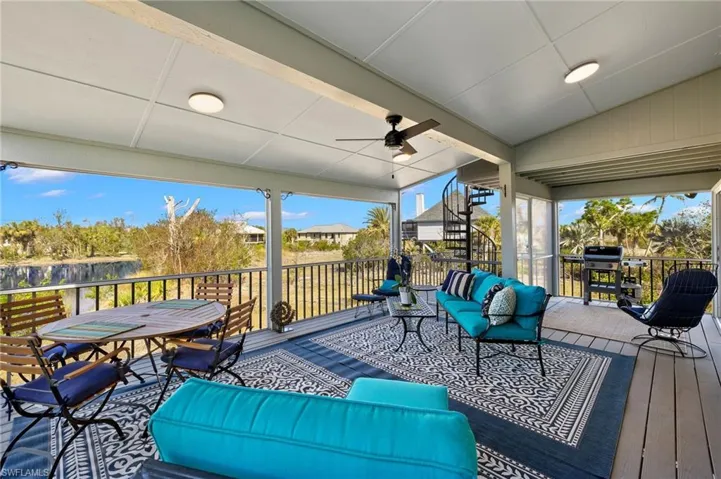 Wooden terrace featuring ceiling fan, an outdoor hangout area, and area for grilling
