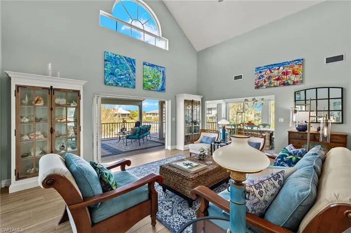 Living room with high vaulted ceiling and wood finished floors