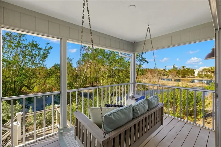 Sunroom featuring a water view and a balcony