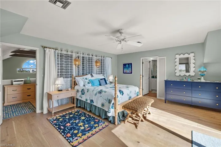 Bedroom with light wood-type flooring, vaulted ceiling, and a ceiling fan