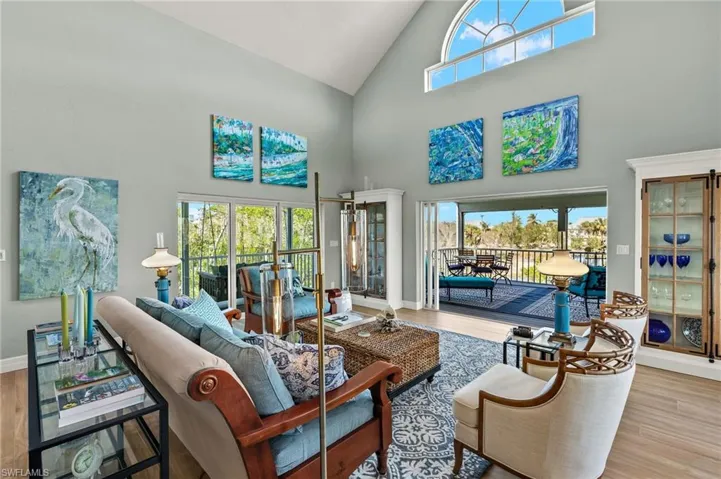 Living room with high vaulted ceiling and wood finished floors