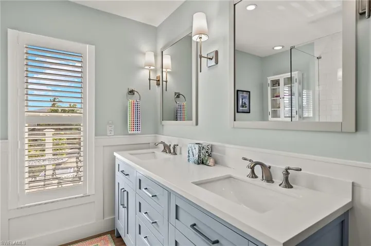 Bathroom featuring double vanity and wainscoting