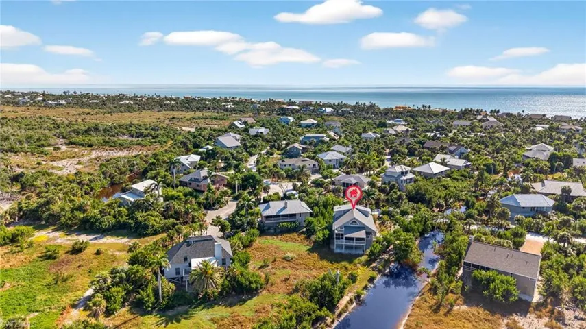 Aerial perspective of suburban area featuring a nearby body of water