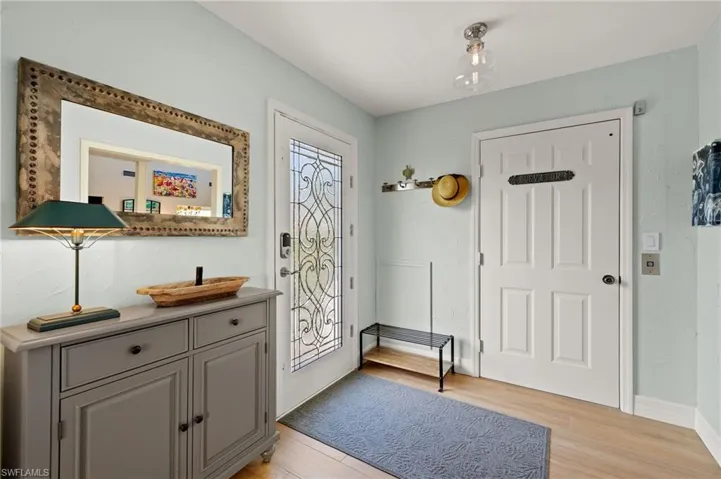 Doorway with wood finished floors and baseboards