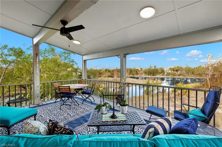 Wooden terrace featuring an outdoor living space, a ceiling fan, a water view, and view of wooded area