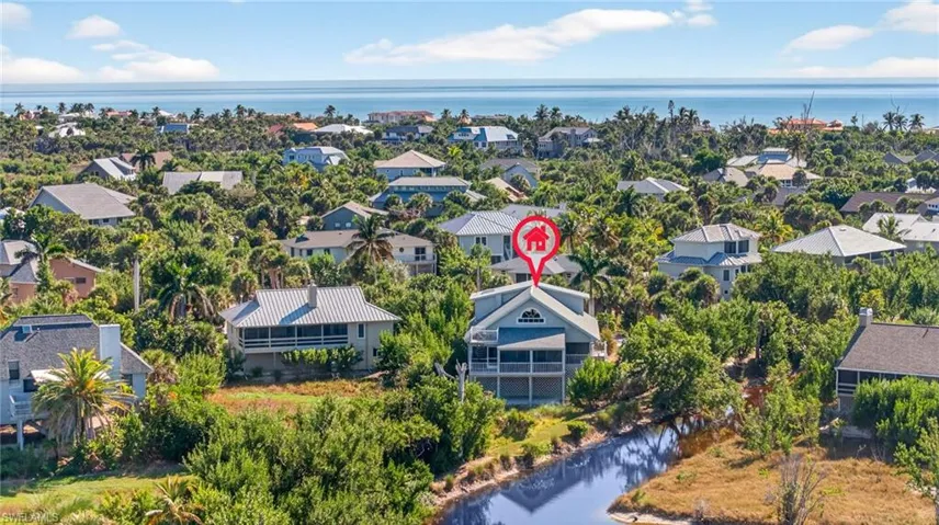 Aerial perspective of suburban area featuring a nearby body of water