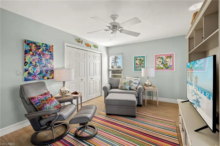 Living area with light wood finished floors and a ceiling fan