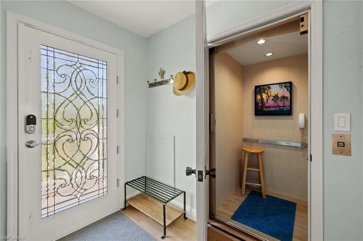 Entrance foyer with elevator, wood finished floors, and recessed lighting